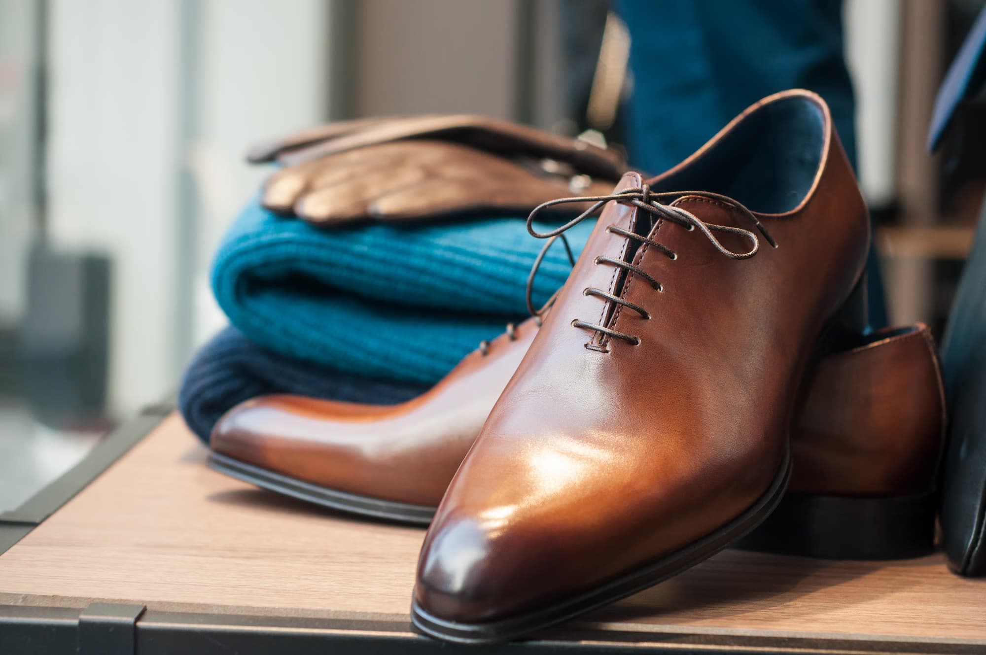 Brown leather dress shoes styled with knitwear in a retail display