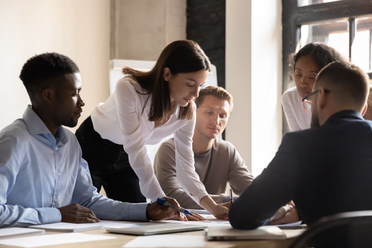 Professional team gathered around a table reviewing documents together