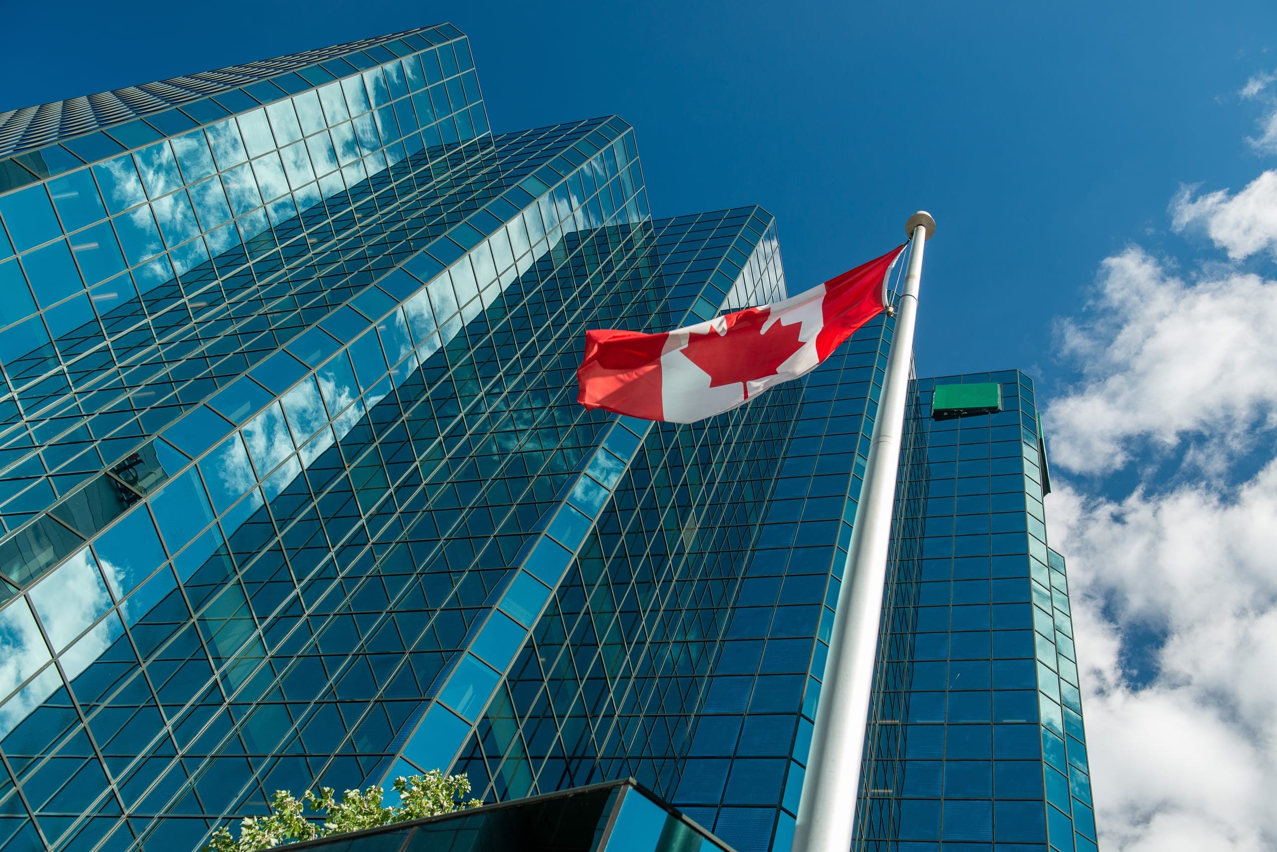 Canadian flag in front of glass office towers in Ottawa