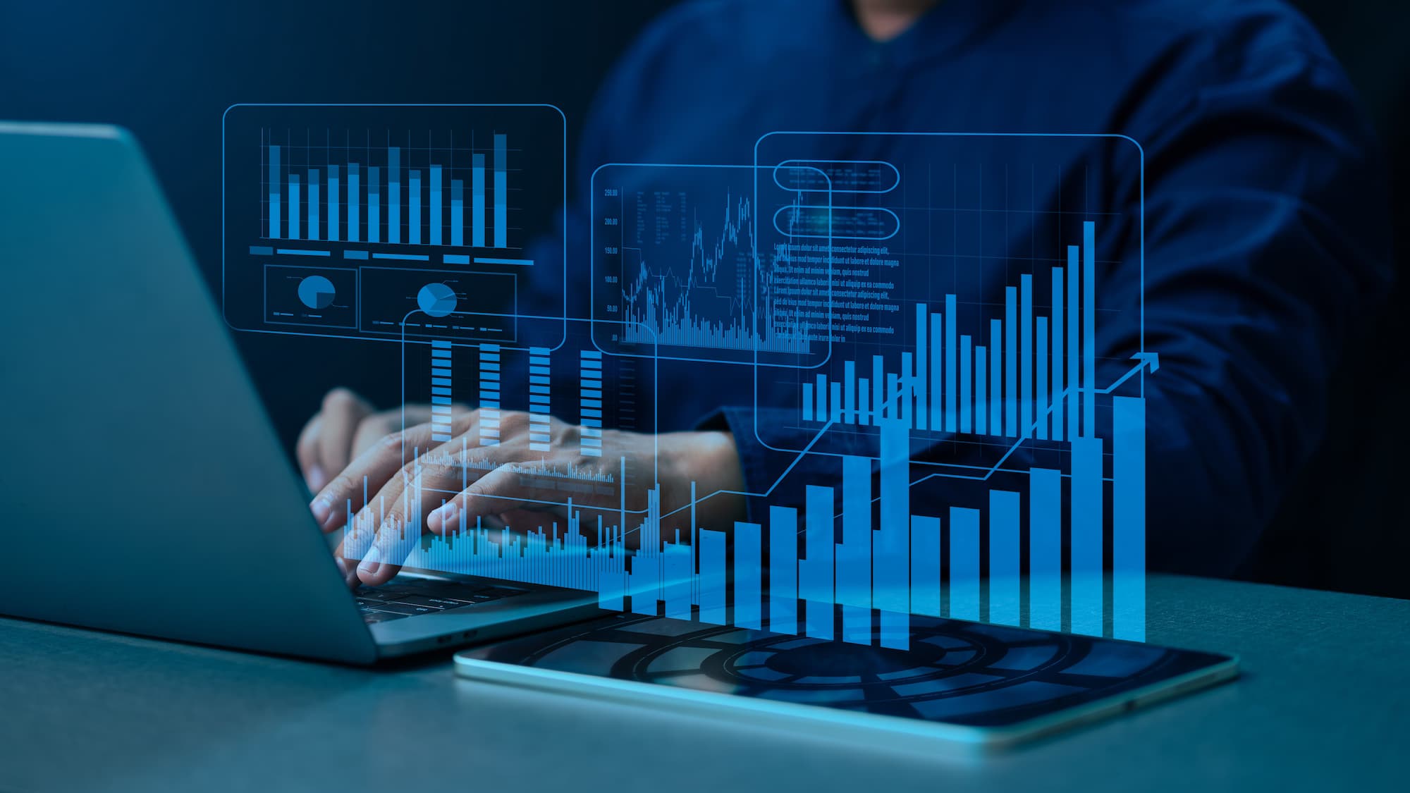Analyst at a laptop reviewing infrastructure metrics on a data dashboard overlay